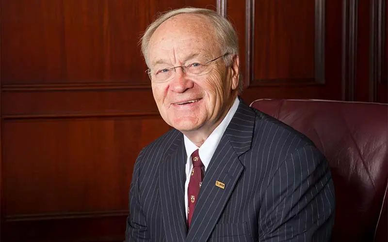 Four men and a woman in dress clothes posing for a photo