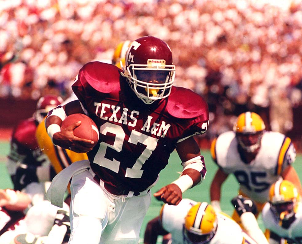 Football player running with the football in a game