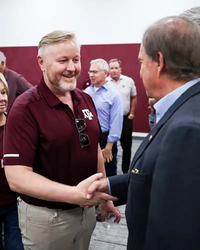 Portrait of Adam Sinn shaking hands