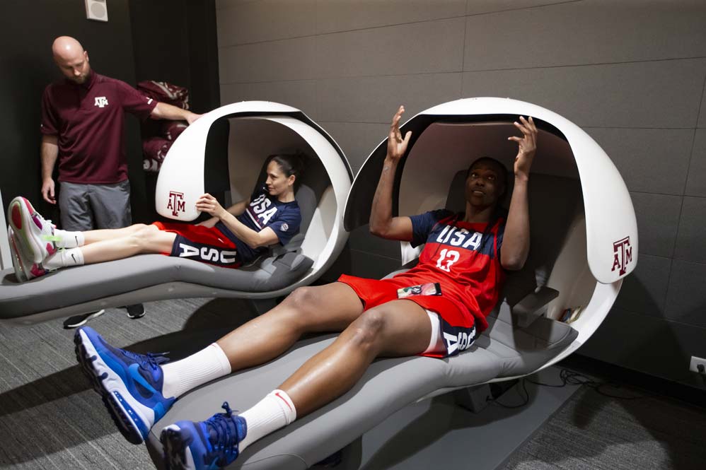 Two basketball players sitting in sleep pods