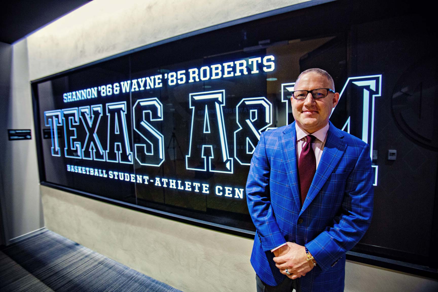 Buzz Williams in front of a Texas A&M sign