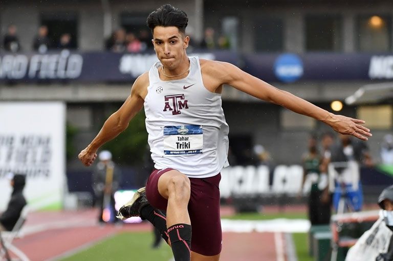 A track athlete jumping over a hurdle