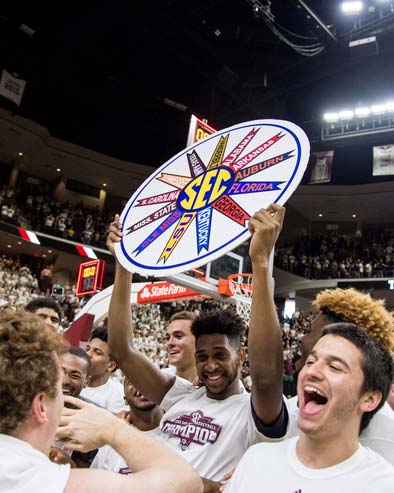 Basketball team holding up SEC trophy