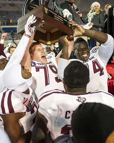 football players holding trophy